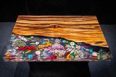 a wooden table topped with lots of colorful beads