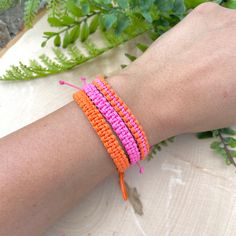 a person's arm with three different colored bracelets on top of each other