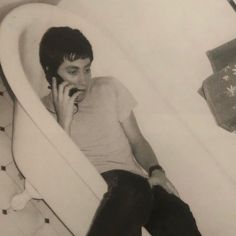 a man sitting in a bathtub talking on a cell phone