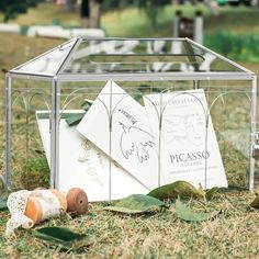 a small glass box with some cards in it on the ground next to other items