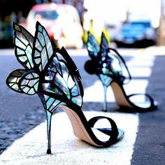 the shoes are decorated with butterfly wings and high heeled heels, all made out of stained glass