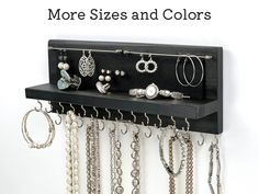 a black shelf with lots of jewelry hanging from it's sides and the words more sizes and colors above it