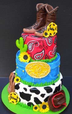 a cake made to look like a cowboy hat, boots and sunflowers on a green plate