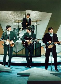 the beatles singing on stage with their guitars