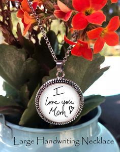 a close up of a flower in a vase on a table with the words i love you mom