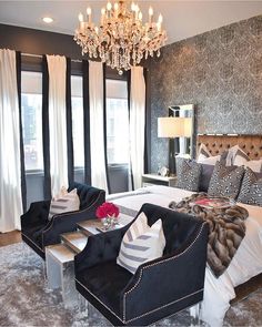 a bedroom decorated in black and white with chandelier