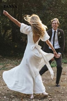 a man and woman are dancing in the woods