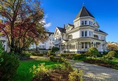 a large white house sitting on top of a lush green field