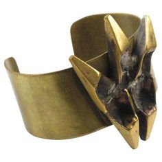 This impressive sculptural brutalist bronze cuff bracelet was designed by French sculptor and painter Henri Nogaret (1927 -). The large brass band is topped with a Mid-Century modernist abstract ornamental sculpture made of gilded bronze. The signature is engraved on the side. Please check our storefront, as we have the matching pendant necklace available. Measurements: circumference is 6.69 in (17 cm) - Opening is 1.25 in (3.2 cm) - Band width is 1.19 in (3 cm) - Sculpture element is 1.69 in wide (4.2 cm) x 2.32 in high (5.8 cm) - Fit a Medium size wrist with an average 6.50 in circumference (16.5 cm). Feel free to double-check the measurements and ask any questions you have before making your purchase. This item is a final sale. No returns will be accepted for an unfit size. Bronze Cuff Bracelet, French Sculptor, Mommy Jewelry, Dagger Earrings, Jewelry Staples, Silver Ring Designs, Antique Bracelets, Enamel Bangle, Bold Jewelry