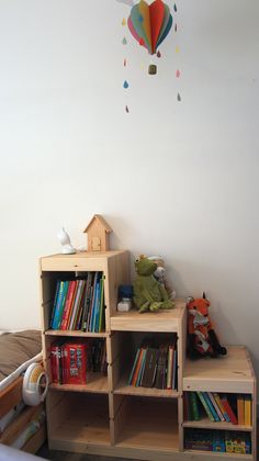 a book shelf with books and toys on it in a child's playroom