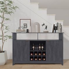 an entertainment center with wine bottles on the bottom shelf and stairs leading up to it