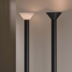 two tall black lamps sitting next to each other