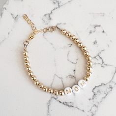 Made of high quality 14k gold filled beads, the NEW Luxe Gold Filled Mom Bracelet makes the sweetest gift or treat for yourself. Great on its own or paired with a watch — always amazing layered. One beaded bracelet Size: 6” + 1.5” gold filled extender 5mm high quality 14k gold filled beads Lobster clasp Does not turn, tarnish, or rust Handmade with the highest standards & quality materials Includes 100% organic cotton jewelry pouch This item is made to order and shipped with love from our studio Adjustable 14k Gold Bracelet With Gold Beads, Beaded 14k Gold Filled Yellow Gold Bracelets, 14k Gold Bracelet With Gold Beads As Gift, Handmade Gold Bracelet In 14k Gold Filled, Adjustable 14k Gold-filled Bracelet With Beads, Adjustable Gold Beaded Bracelets As Gift, Gold 14k Gold-filled Beaded Bracelets, Dainty 14k Gold-filled Beaded Bracelets, Rose Gold 14k Gold-filled Bracelets As Gift