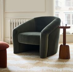 a green chair sitting on top of a rug next to a table