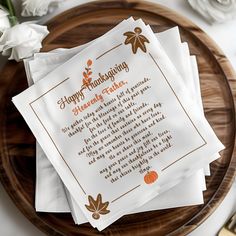 three thanksgiving napkins on top of a wooden plate with white flowers in the background