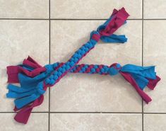 a blue and pink braided rope on a tile floor with tiles in the background