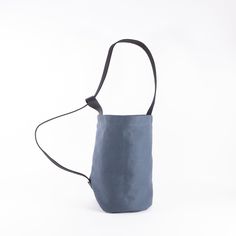 a small blue bag with a black strap hanging from it's side on a white background