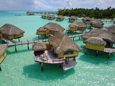 the water is crystal blue and clear with many huts