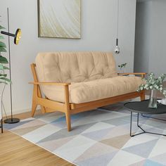 a living room with a futon, coffee table and potted plant in it