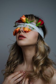 a woman with flowers on her face and blindfold