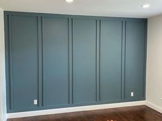 an empty room with blue walls and wood floors