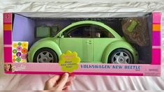 a green toy car in a pink box