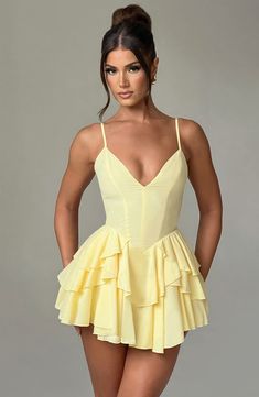 Wear this pretty playsuit on repeat. cut from our premium chiffon which is super floaty and lightweight. Featuring a layered ruffle skirt with built in shorts. this plunge neck design is backless with adjustable straps for your perfect fit. Partner with barely there heeled sandals and a bright bag.   Colour: Lemon. Premium non-stretch chiffon. Fully lined. Layered ruffle skirt with built in shorts. Plunge neckline. Adjustable straps. Internal tie at waist. Backless design. Invisible zipper to reverse. Mini length. Model is an XS and is wearing an XS. Glamorous Cheap Mini Dress, Luxury Mini Dress For Summer, Luxury Chic Mini Dress For Brunch, Cute Cheap Yellow Mini Dress, Luxury Summer Mini Dress For Wedding Guest, Luxury Ruffled Mini Dress For Summer, Luxury Ruffle Mini Dress For Summer, Luxury Retro Mini Dress For Summer, Luxury Mini Dress With Folds For Summer