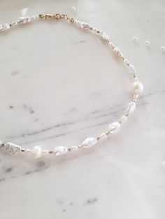 This gorgeous and unique necklace features natural freeform biwa Pearl's and freshwater Pearl's of all shapes and sizes for a high end custom effect. Faceted metal beads are spaced throughout for shimmer and shine. ✨ Handmade from top quality materials, 925 sterling silver or 14k gold fill. Gold fill is much higher quality than gold plated jewelry and contains 100 times more gold! People with highly sensitive skin can usually wear gold fill with no problems. Hypoallergenic, lead and nickel free. Delicate Baroque Pearl Bracelet With Pearl Chain, Delicate Baroque Pearl Chain Bracelet, Delicate Baroque Pearl Bracelet, Dainty Single Strand Akoya Pearl Necklace, Dainty Akoya Pearl Single Strand Necklace, Delicate Single Strand Baroque Pearl Necklace, Pearl-embellished Choker Necklace For Gifts, Minimalist Handmade Pearl White Necklace, Minimalist Single Strand Baroque Pearl Necklace