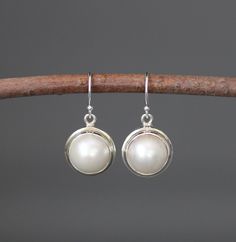 "Gorgeous round white freshwater pearls are bezel set in simple Bali Silver charms.  These dangle from silver earwires.   Choose from balled silver earwires (as shown and sent with stoppers for the ends of the wires) or plain leverback earwires (these close in the back).  These elegant earrings are perfect for any occasion!   Pearl bezels: 11mm Bali Silver charms: 13x16mm (including the silver ring) Total length of earrings: just over 1\" Length is approximate. All silver is sterling. As the own Classic Round Pearl Earrings For Everyday, Minimalist Round Pearl White Earrings, Pearl White Round Earrings For Everyday, Everyday White Pearl Pendant Earrings, Minimalist Round Pearl Drop Earrings, Nickel Free Classic Dangle Pearl Earrings, Classic Nickel-free Dangle Pearl Earrings, Classic Sterling Silver Pearl Pendant Earrings, Everyday White Round Pearl Earrings