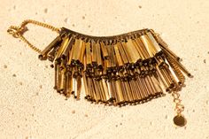 a gold necklace with chains hanging from it