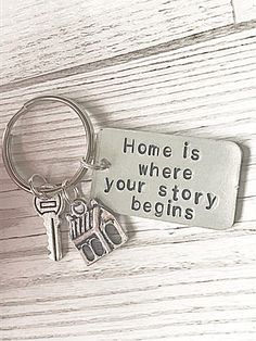 a keychain that says home is where your story begins on the front and back