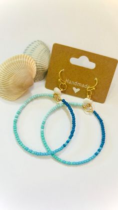 These ocean blue inspired beaded hoops will look great with a maxi dress on your next vacation to the beach!  Beaded Hoops Details:  - handmade  - ombre effect ocean blue seed beads  - white gemstone (howlite) resembling a seashell - hypoallergenic french hooks  *when you buy the whole vacation collection, shipping is free!* Handmade Blue Summer Jewelry, Handmade Summer Blue Jewelry, Bohemian Round Earrings For The Beach, Summer Beach Beaded Earrings With Dangling Beads, Bohemian Dangle Beaded Earrings For Vacation, Handmade Ocean Color Jewelry For Summer, Bohemian Beaded Earrings For Vacation, Summer Beach Beaded Earrings, Handmade Ocean Color Summer Jewelry