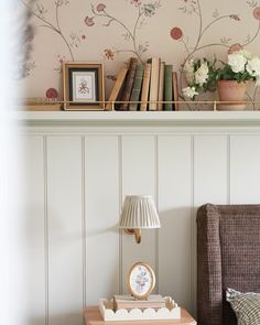 there is a shelf with books and flowers on it