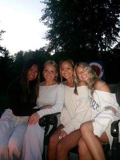 four women are sitting on a bench together