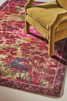 a yellow chair sitting on top of a pink rug