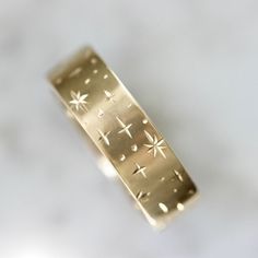 a close up of a gold ring with stars on it