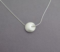 Delicate silver necklace for yourself or as a gift, with a unique bead. Both sides of the bead look the same, it's diameter is about 1.6 cm - 0.6 inch, with a grainy textured matte finish. The chain is 40 cm/16 inch long. Please contact me if you like to have a longer chain. I also have this necklace in 14k gold, with a smaller bead, here: https://www.etsy.com/listing/74255864 For another version of this necklace, click here: https://www.etsy.com/listing/79578221 To get back to my shop, click he Silver Ball Chain Necklace As A Gift, Silver Necklace With Ball Chain As Gift, Silver Necklace With Ball Chain For Gift, Minimalist Round Bead Necklaces For Gifts, Minimalist Round Bead Charm Necklace As Gift, Sterling Silver Charm Necklaces With Round Beads, Circular Silver Chain Necklace Gift, Gift Sterling Silver Necklace With Spacer Beads, Gift Silver Chain Necklace