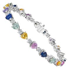 • 18KT White Gold • 13.48 Carats • 7" Long • Number of Round Diamonds: 20 • Carat Weight: 2.91ctw • Number of Heart Shape Sapphires: 20 • Carat Weight: 10.54ctw This beautiful bracelet contains a row 20 heart shape sapphires & round white diamonds with a combining total weight of 13.45 carats. The sapphires range in color from blue, yellow, teal, green, and pink. Set in 18KT white gold, this bracelet measures 7” long. Each stone has been carefully matched and set by hand in New York City. Elegant Multicolor Sapphire Bracelets, Multi Color Sapphire Bracelet, Luxury Multicolor Multi-stone Diamond Bracelet, Elegant Multi-stone Sapphire Bracelet, Elegant Sapphire Multi-stone Bracelet, Modern Bracelets, Colorful Heart, Sapphire Diamond, Beautiful Bracelet