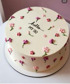 a white cake decorated with pink flowers and the words hello m & b on it