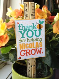 there is a sign that says thank you for helping nicholas grow in front of some flowers