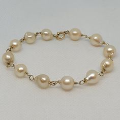 Lovely 12kt yellow twisted gold link bracelet with twelve 8.5mm cream-white freshwater pearls. The freshwater pearls have a lustrous clean nacre. The bracelet is 7.75 inches long, secured with a spring ring clasp, and weighs 10.6 grams.  Rock N Gold Creations is located in San Diego, California, serving customers locally, nationally, and internationally for over 30 years. Pre-owned jewelry and watches are evaluated before they are listed. The founder is a GIA graduate; the company adheres to GIA standards. Rock N Gold Creations has won many jewelry design competitions and has a passion for providing quality custom jewelry, fine estate jewelry, and fine watches. Classic Gold Bracelet With Pearl Drop, Classic Gold Pearl Drop Bracelet, Gold Pearl Bracelet With Pearl Charm For Formal Occasions, Formal Gold Bracelet With Pearl Drop, Elegant Cream Bracelet For Formal Occasions, Elegant Cream Bracelet For Formal, Elegant Cream Pearl Bracelet For Formal Occasions, Classic Gold Pearl Bracelet Hypoallergenic, Classic Yellow Gold Pearl Drop Bracelet