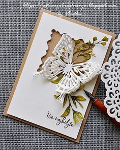 a close up of a greeting card on a table with scissors and paper doily