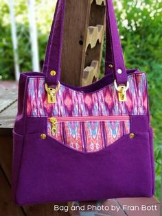 a purple purse sitting on top of a wooden bench