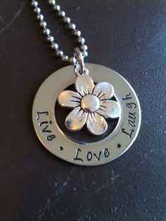 a necklace with a flower on it that says, life is love and all things are possible