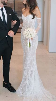 a man in a tuxedo standing next to a woman in a wedding dress