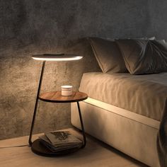 a table with a cup on it next to a bed