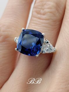 a woman's engagement ring with a blue sapphire and diamond accents on the band