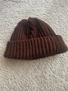 a brown knitted hat laying on the floor