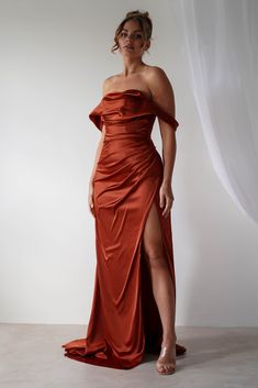 a woman in an orange dress posing for the camera