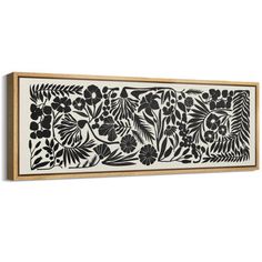 a black and white floral design on a wooden frame hanging on the wall in front of a